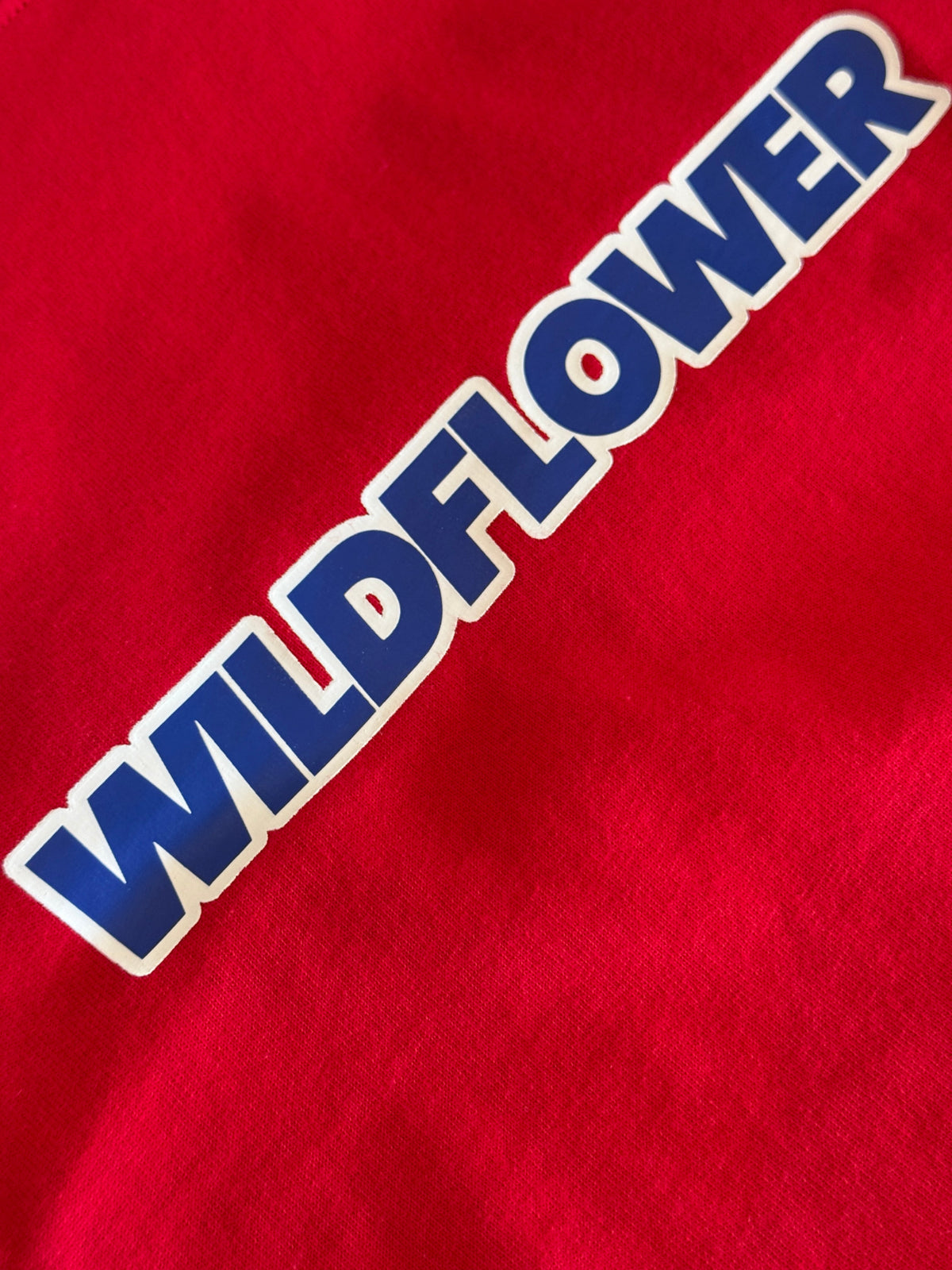 The Red and Blue Tee, Wildflower logo close up